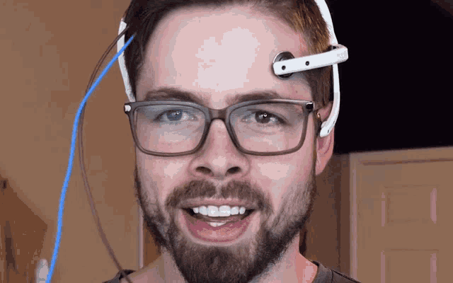 a man with glasses and a headset on his forehead