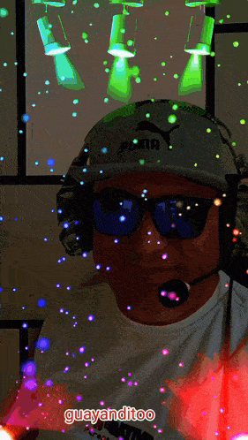 a man wearing headphones and sunglasses is surrounded by glowing lights and says guayanditoo
