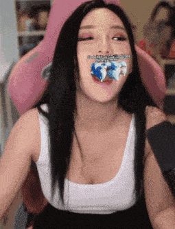 a woman sitting in a pink chair with a sticker on her mouth that says ' end the ice age '