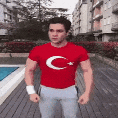 a man wearing a red t-shirt with a white crescent moon and star on it