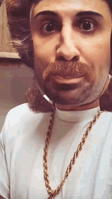 a man wearing a white shirt and a gold chain
