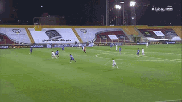 a soccer game is being played in an empty stadium with advertisements for etihad