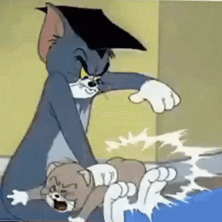 tom and jerry are playing with each other in a room . tom is wearing a graduation cap .