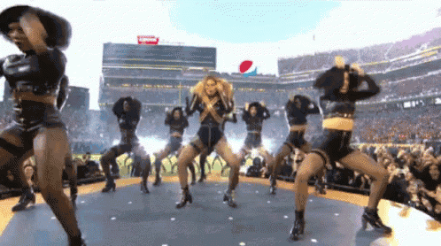 a group of women are dancing on a stage in front of a pepsi sign .
