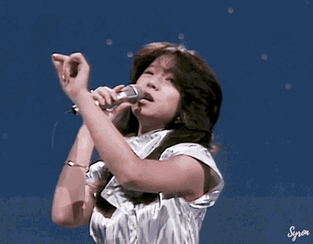 a woman singing into a microphone with the word syron written below her
