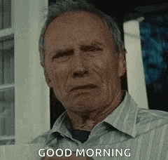 a man in a striped shirt is standing in front of a window and saying good morning .