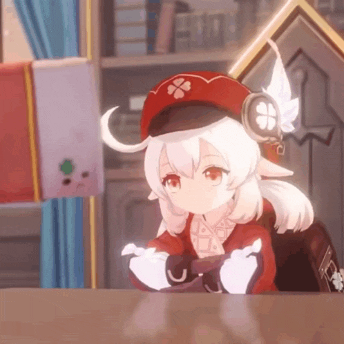 a girl in a red hat is sitting at a table in a video game .