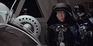 a man in a helmet is standing in front of a steering wheel in a vehicle .