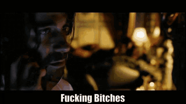 a man with a beard is talking on a cell phone with the words " fucking bitches " below him
