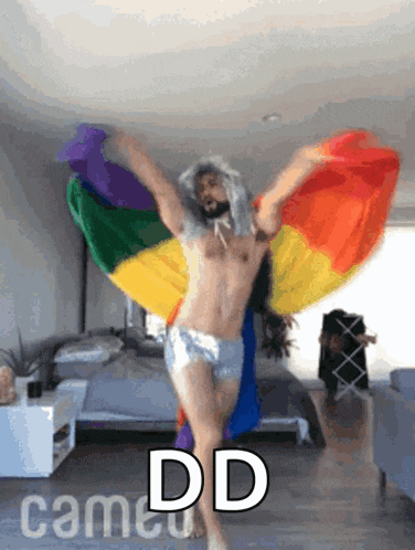 a shirtless man is dancing in front of a rainbow flag with the words " dd came " below him