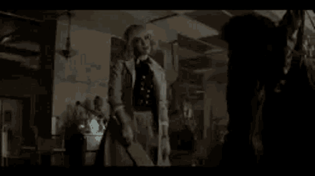 a woman in a white dress is standing in a dark room with a ghost .