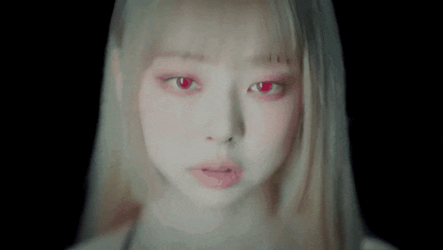 a close up of a woman 's face with red eyes and blonde hair .