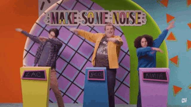 a group of people are standing in front of a wall that says make some noises