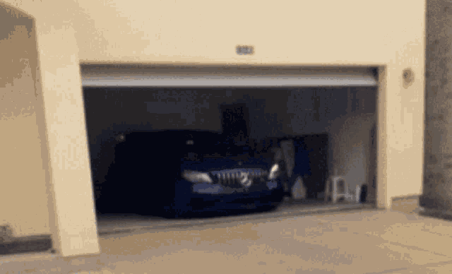 a blue car is parked in a garage with the number 912 on the wall behind it