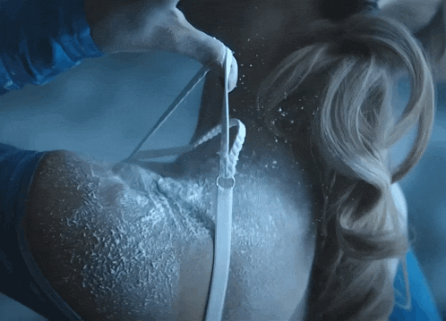 a woman 's back is covered in ice and a person is holding a white object