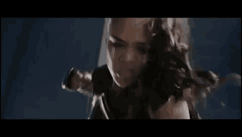 a close up of a person 's face with a gun in a dark room .