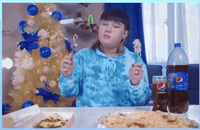 a man is sitting at a table eating a pizza and drinking pepsi .