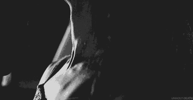a black and white photo of a woman 's neck and chest