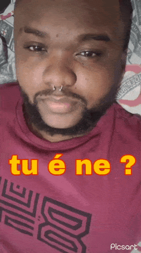 a man with a beard is wearing a red shirt that says " tu e ne "