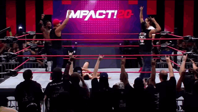 wrestlers in a ring with a sign that says impact20 on it