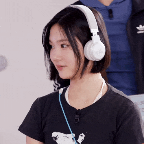 a woman wearing a black shirt and white headphones with jbl written on them