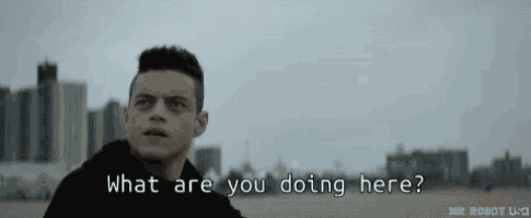 a man is standing in front of a city skyline with the words `` what are you doing here '' .