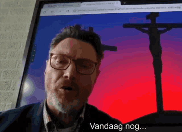 a man with glasses and a beard is talking in front of a screen that says ' vandaag nog ' on it