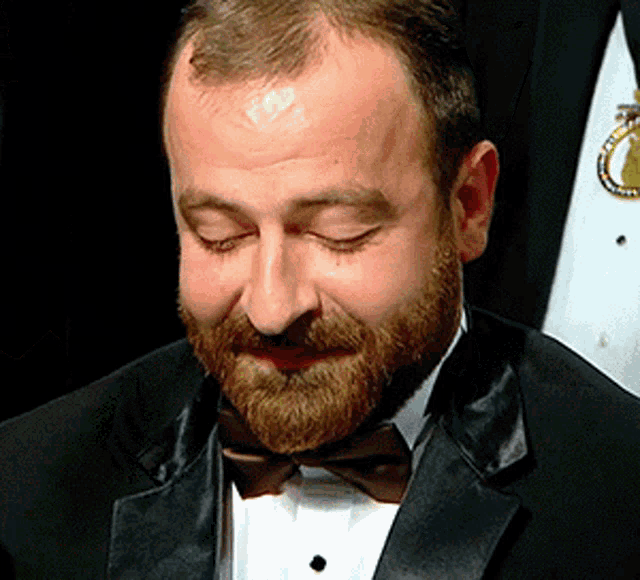 a man with a beard wearing a black tuxedo and bow tie