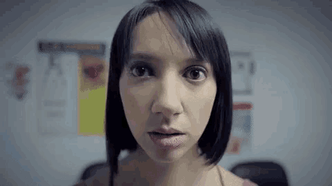 a close up of a woman 's face looking at the camera with her mouth open .