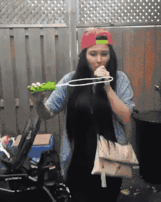 a woman wearing a pink hat blowing bubbles
