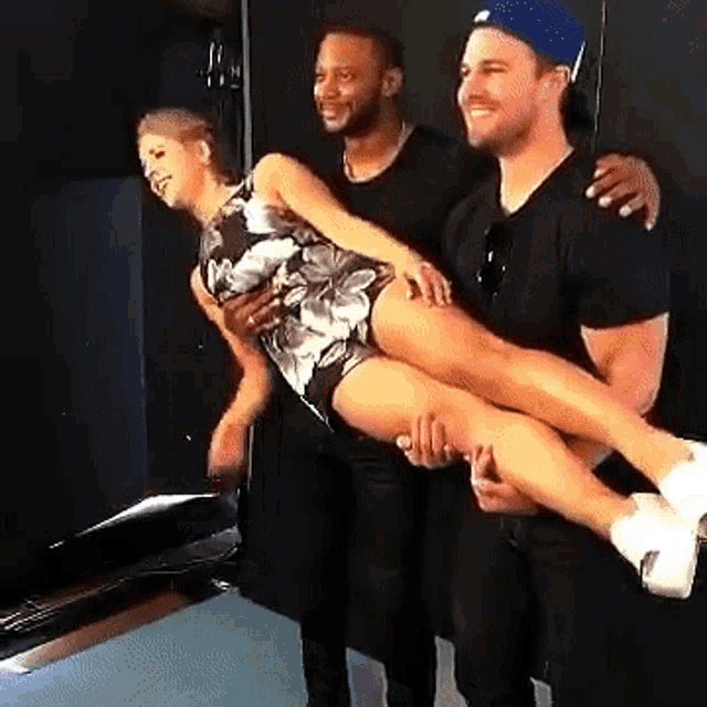 a man is carrying a woman in his arms and they are posing for a picture together .