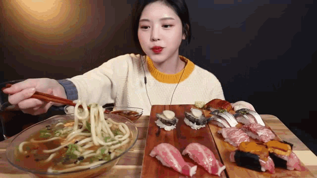 a woman is eating noodles and sushi on a table