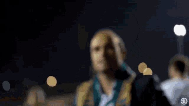 a blurry picture of a man wearing a green and yellow jacket .
