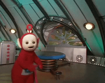 a teletubbies character is standing in a room with a table