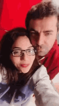 a man and a woman are taking a selfie together .
