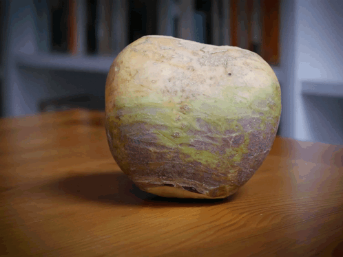 a large potato is sitting on a wooden surface