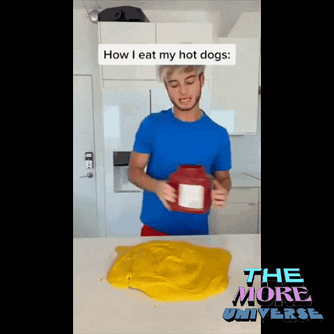 a man in a blue shirt is holding a ketchup bottle with the words how i eat my hot dogs above him