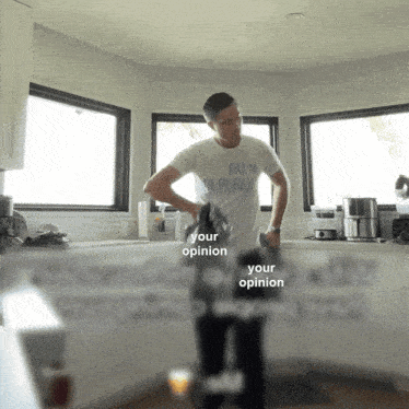 a man in a palm public t-shirt is standing in a kitchen