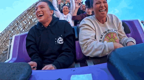 two women are riding a roller coaster and one has a shirt that says " sex to die for "