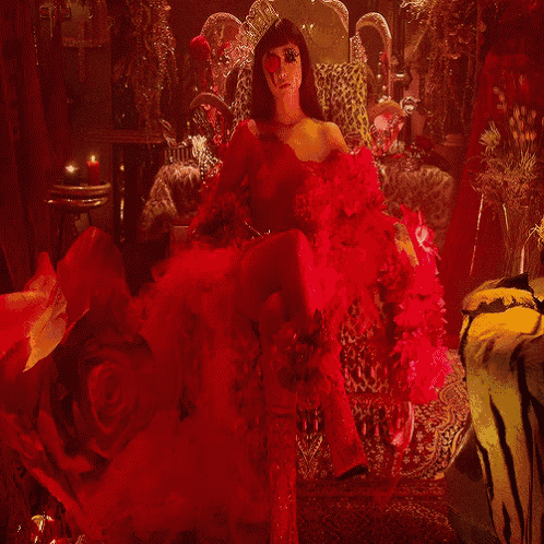 a woman in a red dress is sitting in a leopard print chair