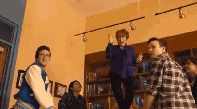 a group of people are standing in a room and one of them has the letter s on their jacket