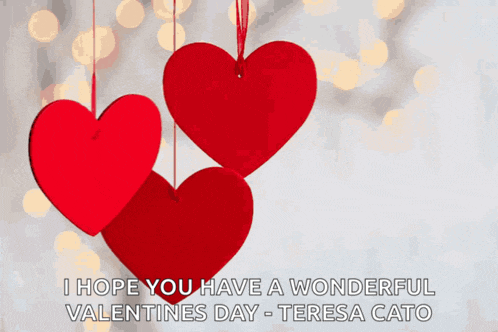 a valentine 's day card with three hearts hanging from a string