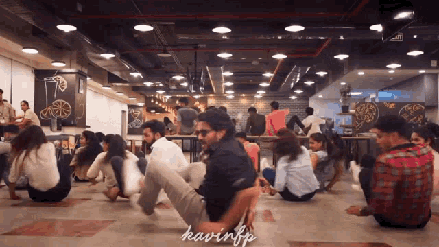 a group of people are sitting on the floor in a room with kavinfp written on the bottom right