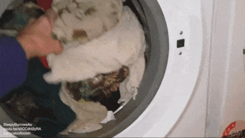 a person is putting clothes in a washing machine and the url for the video is sleepyburrowsau