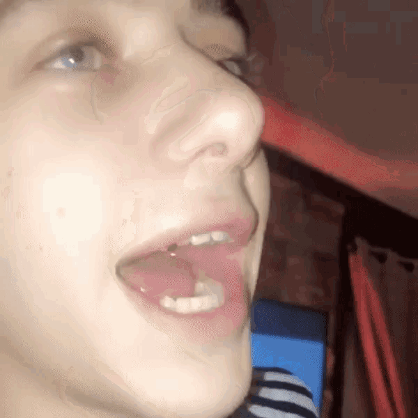 a close up of a person 's face with their mouth open showing their teeth