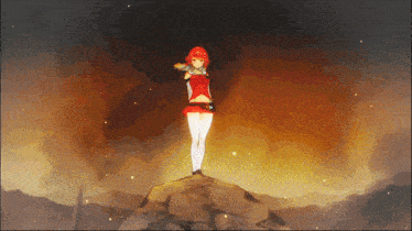 a girl in a red dress is standing on a rock in front of a fire
