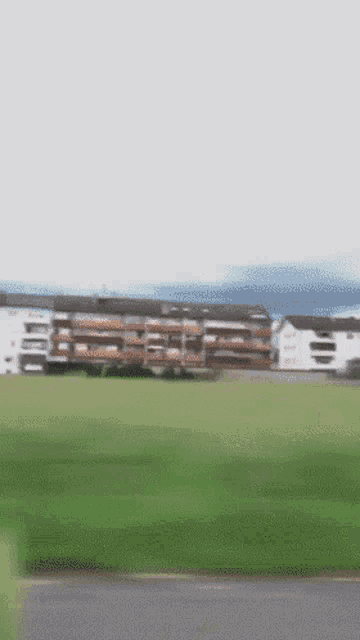 a blurry picture of a field with a building in the distance