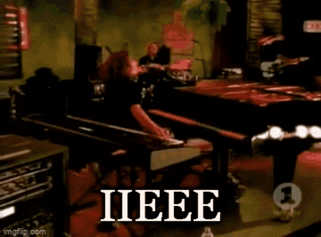 a man playing a piano with the word iieee on the bottom right