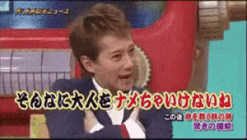 a man in a suit and tie is on a television screen with foreign writing on it