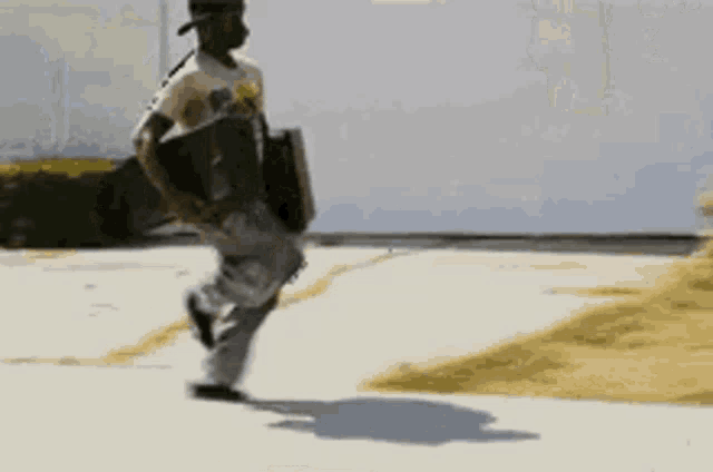 a man is running down a sidewalk holding a skateboard